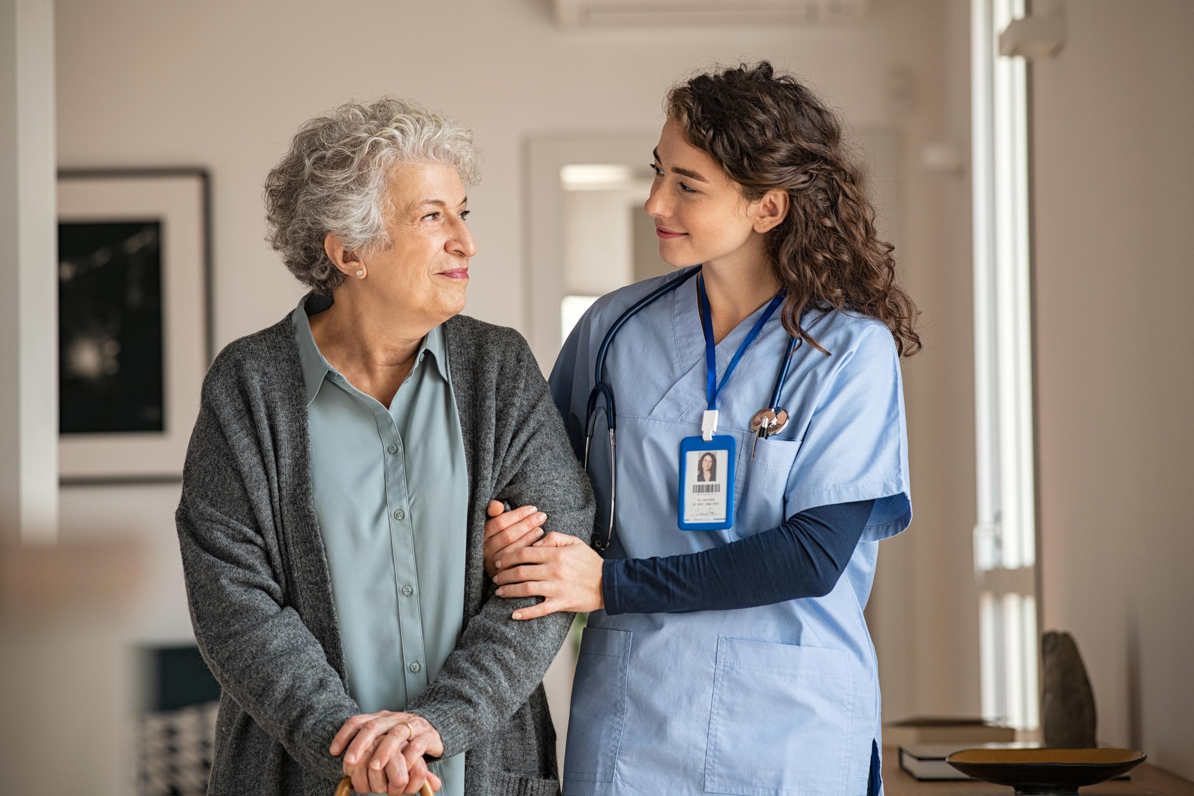 Healthcare worker holding woman's arm.